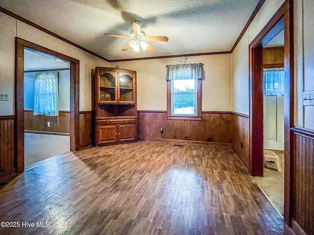 434 Farless Rd, Merry Hill, NC 27957 - empty room featuring wainscoting, wood finished floors, ornamental molding, a ceiling fan, and a textured ceiling