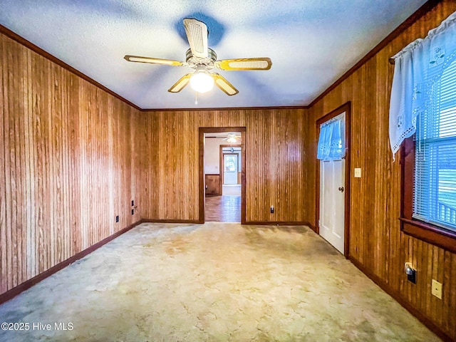 434 Farless Rd, Merry Hill, NC 27957 - unfurnished room featuring wooden walls, carpet, a ceiling fan, ornamental molding, and baseboards