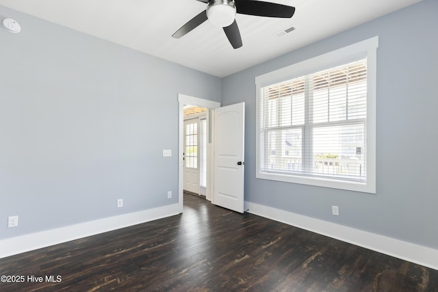 spare room with wood finished floors, a ceiling fan, baseboards, and a smoke detector