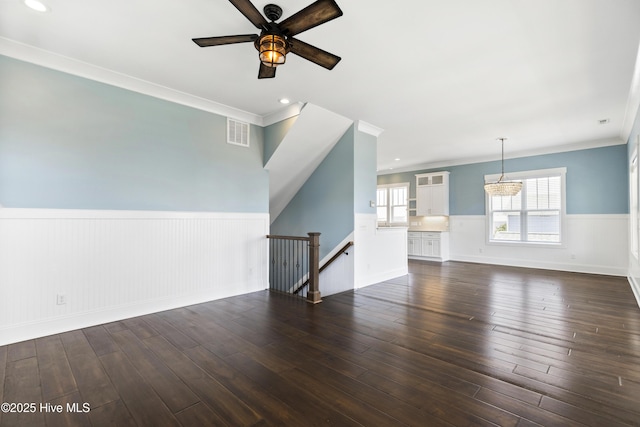 unfurnished living room featuring a wainscoted wall, ceiling fan, dark wood-style floors, ornamental molding, and recessed lighting