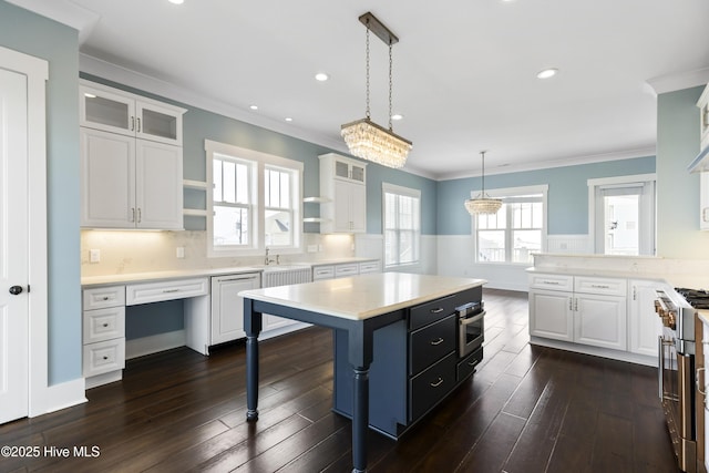 kitchen featuring appliances with stainless steel finishes, light countertops, open shelves, dark wood finished floors, and ornamental molding