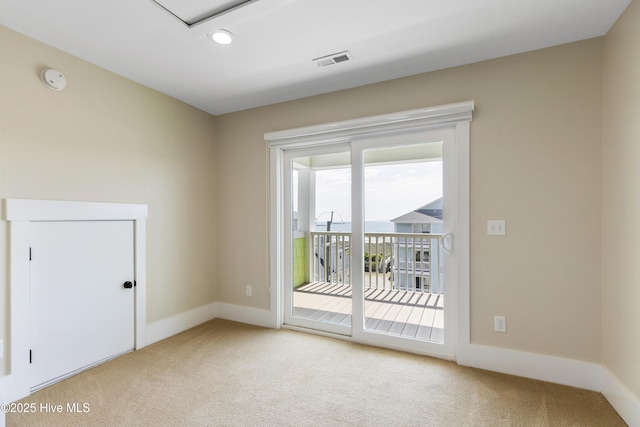 empty room featuring light carpet and baseboards