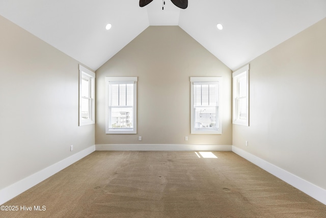empty room with ceiling fan, light colored carpet, lofted ceiling, baseboards, and recessed lighting