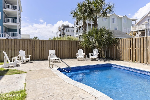 view of swimming pool featuring a patio, a fenced backyard, and a residential view
