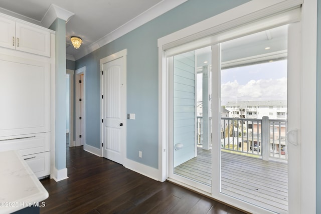 doorway to outside with dark wood finished floors, ornamental molding, and baseboards