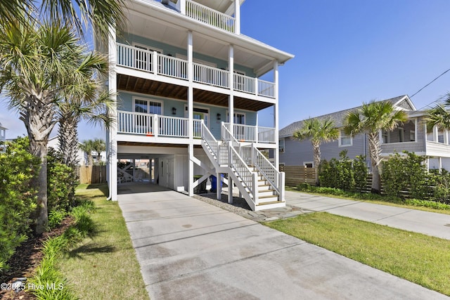 raised beach house with a carport and driveway