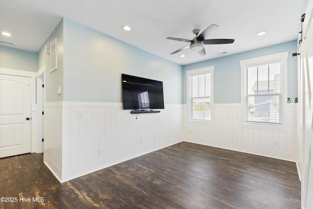 unfurnished living room with wainscoting, wood finished floors, a ceiling fan, and recessed lighting