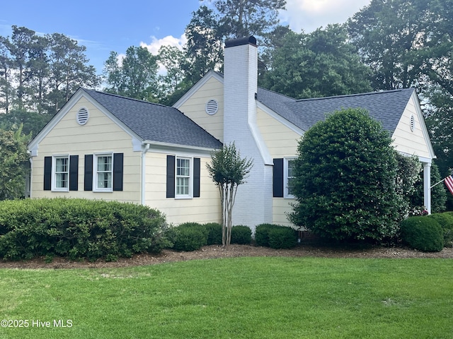 310 N Franklin St, Whiteville, NC 28472 - view of property exterior featuring roof with shingles, a chimney, and a lawn