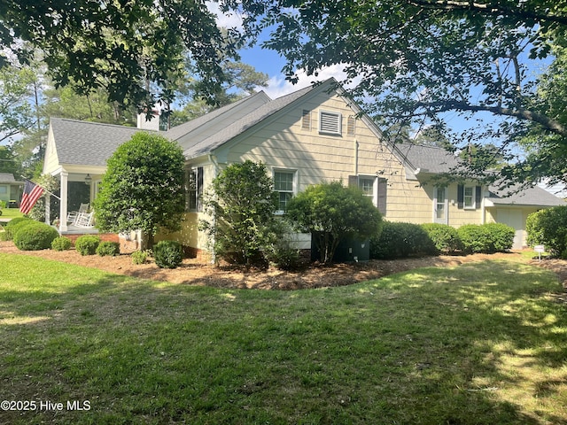 310 N Franklin St, Whiteville, NC 28472 - view of home's exterior featuring a lawn, roof with shingles, and a chimney