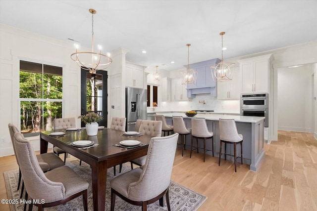 dining area with a chandelier, light wood finished floors, and recessed lighting