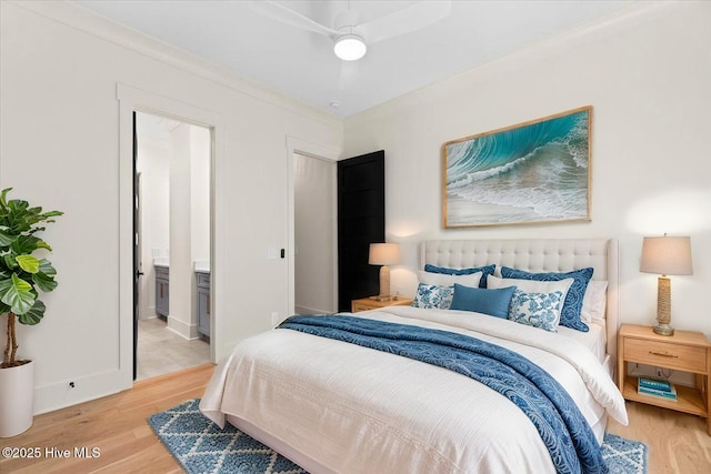 bedroom featuring light wood-style floors, connected bathroom, and baseboards