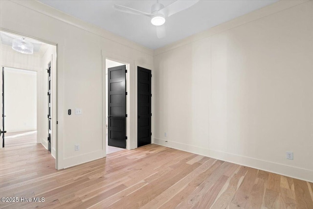 empty room featuring light wood-style flooring, a ceiling fan, and baseboards
