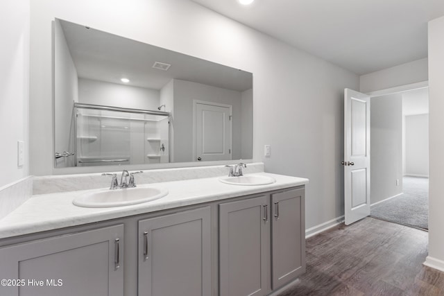3522 Wigeon Way, Winnabow, NC 28479 - bathroom featuring a shower with shower door, double vanity, wood finished floors, baseboards, and recessed lighting