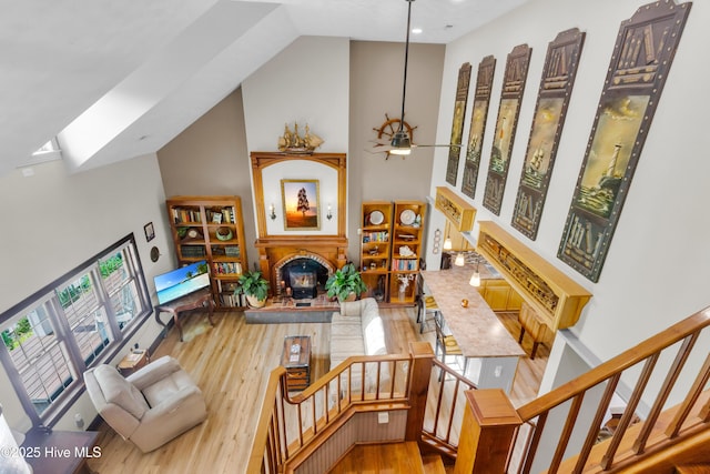 3297 Bay City Rd, Aurora, NC 27806 - rec room with a lit fireplace, high vaulted ceiling, wood finished floors, ceiling fan, and a skylight