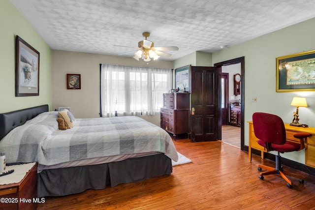 3297 Bay City Rd, Aurora, NC 27806 - bedroom featuring a textured ceiling, light wood finished floors, a desk, and ceiling fan