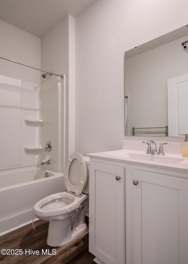 bathroom with toilet, vanity, bathtub / shower combination, and wood finished floors
