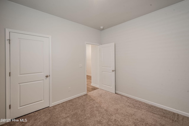 unfurnished bedroom with carpet and baseboards