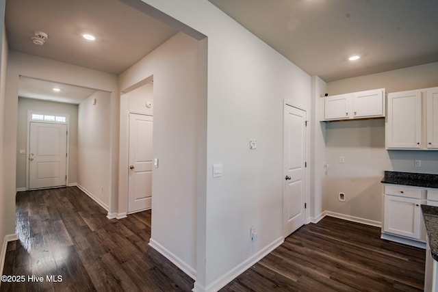 kitchen with dark wood-style flooring, white cabinets, baseboards, recessed lighting, and dark stone counters