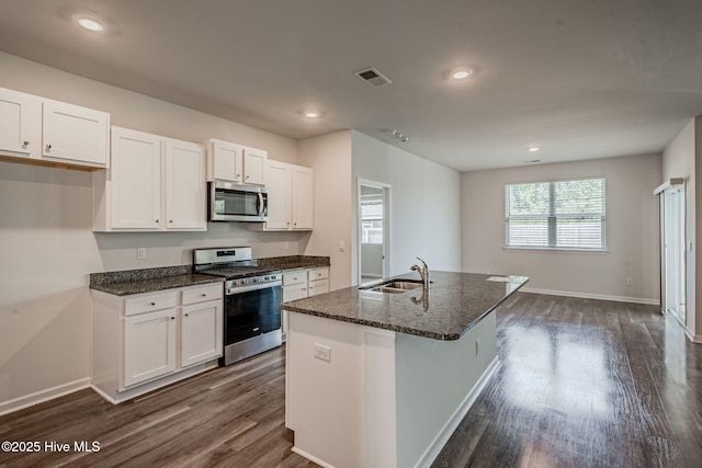 kitchen featuring appliances with stainless steel finishes, a sink, dark wood-type flooring, white cabinetry, and recessed lighting