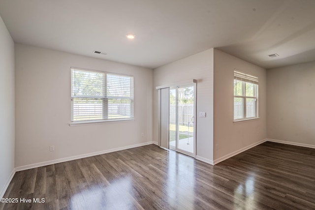 empty room featuring dark wood-style flooring and baseboards