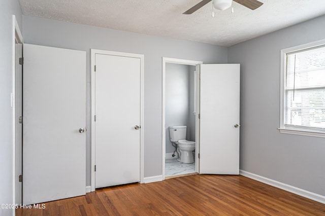 137 Pinecrest Trl, Rockingham, NC 28379 - unfurnished bedroom featuring wood finished floors, baseboards, ensuite bath, and a textured ceiling