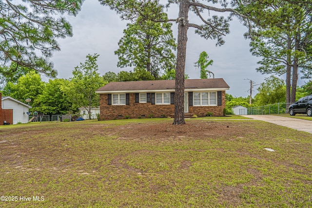 137 Pinecrest Trl, Rockingham, NC 28379 - single story home with driveway, brick siding, crawl space, a storage unit, and an outbuilding