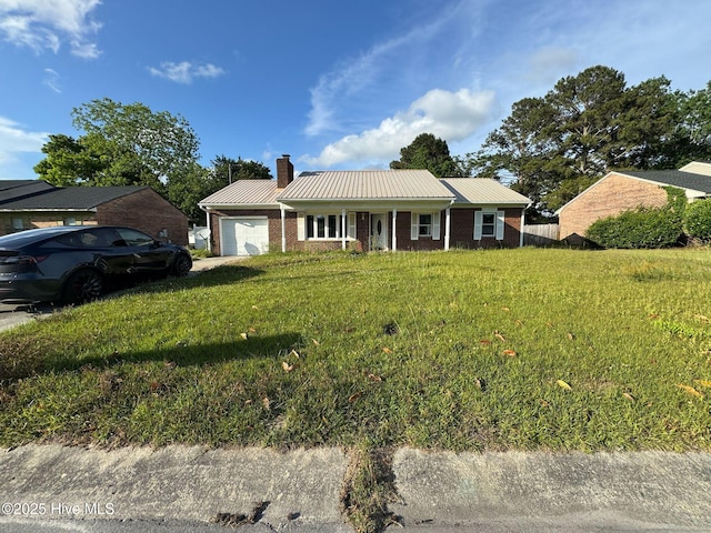 7 Walnut Dr, Jacksonville, NC 28546 - view of front of home featuring a garage, a chimney, metal roof, a front lawn, and brick siding