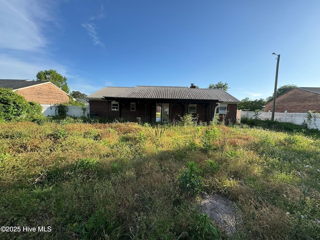 7 Walnut Dr, Jacksonville, NC 28546 - rear view of house with fence, metal roof, and a chimney