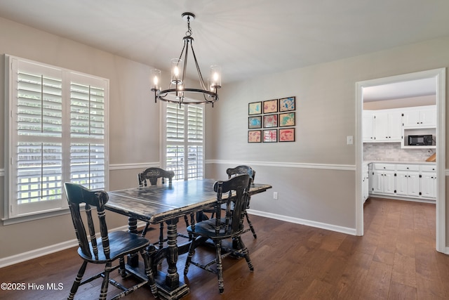 338 Country Club Rd, Camden, NC 27921 - dining area featuring a chandelier, dark wood-type flooring, and baseboards