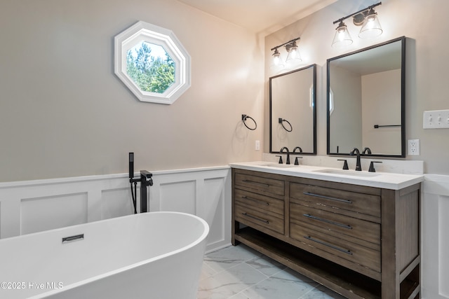 338 Country Club Rd, Camden, NC 27921 - full bath featuring marble finish flooring, double vanity, a freestanding bath, a wainscoted wall, and a decorative wall