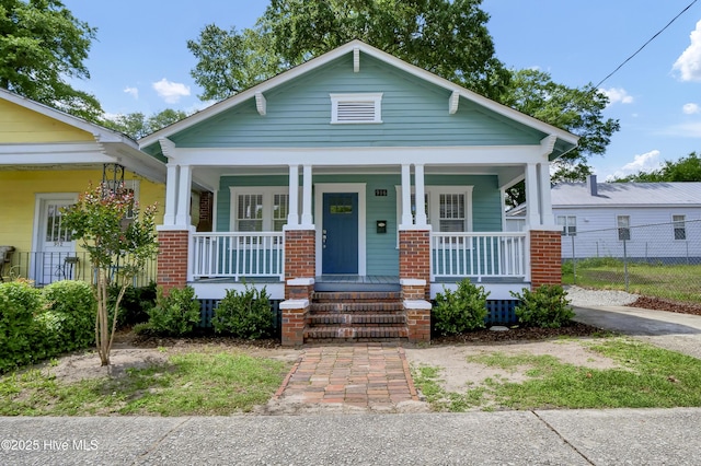 view of front of house featuring covered porch and fence