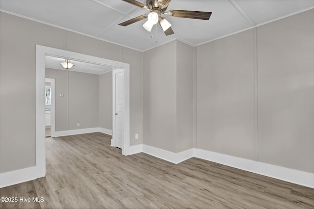 spare room featuring ceiling fan, wood finished floors, crown molding, and baseboards