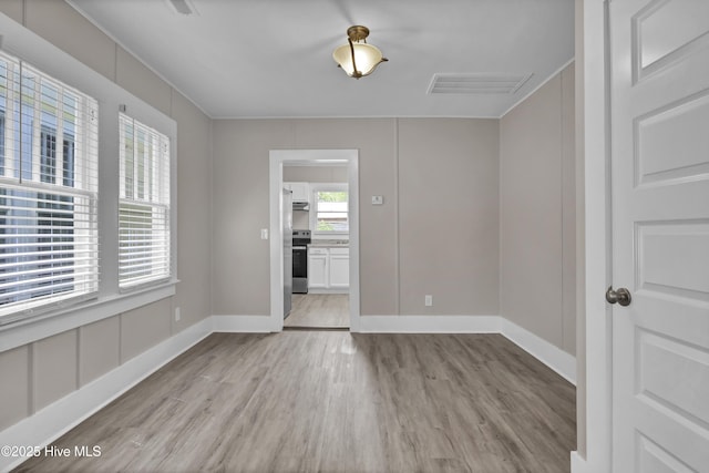 unfurnished dining area featuring light wood-style floors and baseboards