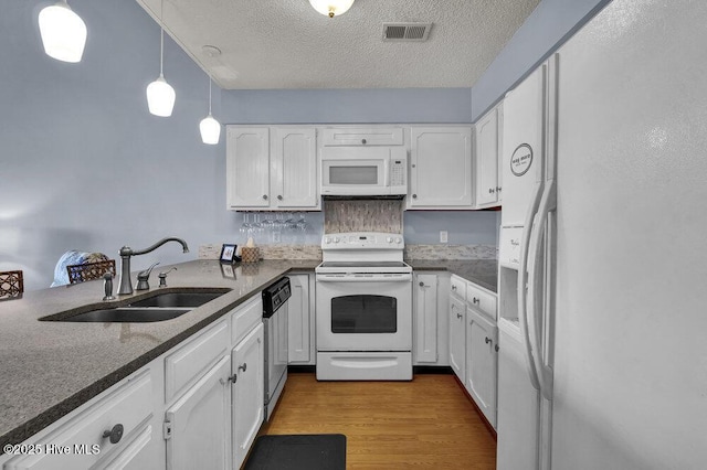 1912 Goose Creek Rd SW Unit 4302, Ocean Isle Beach, NC 28469 - kitchen with white appliances, a sink, white cabinetry, and a textured ceiling