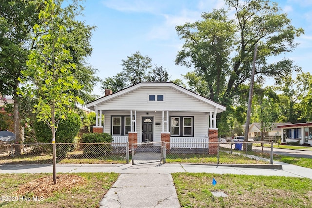 view of front of home with covered porch, a fenced front yard, a gate, and a chimney