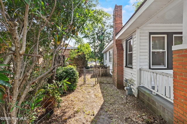 view of side of property with a chimney and fence
