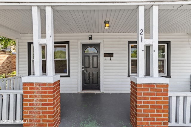 view of exterior entry featuring covered porch