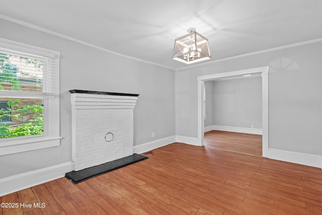 unfurnished room featuring a chandelier, baseboards, ornamental molding, and wood finished floors