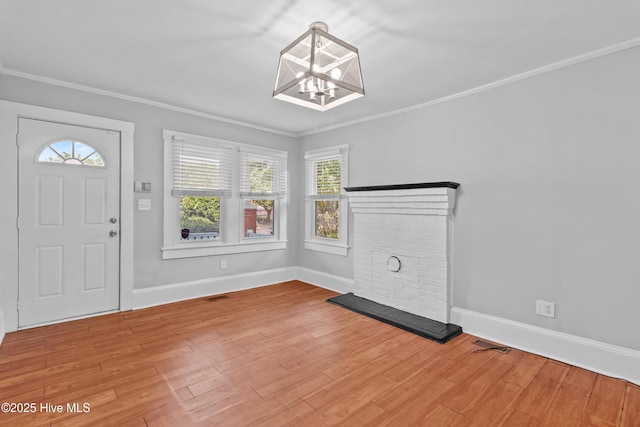 foyer featuring a chandelier, ornamental molding, wood finished floors, and baseboards