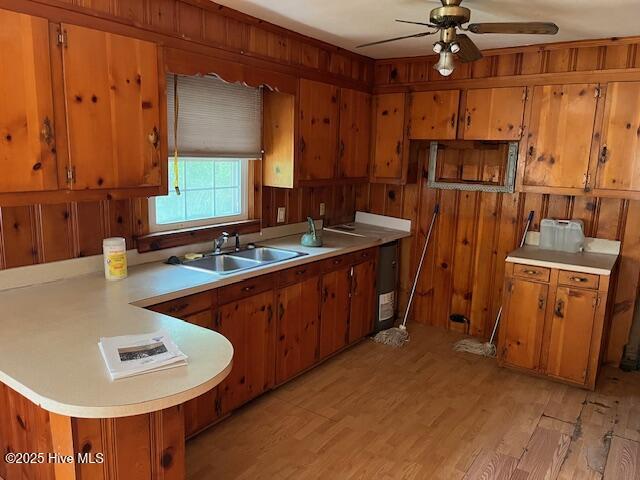 1616 Hwy 58 S, Snow Hill, NC 28580 - kitchen with brown cabinetry, light countertops, a peninsula, a ceiling fan, and wooden walls