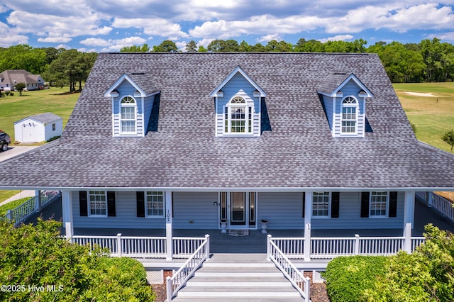 view of front of home with roof with shingles, stairway, and a front lawn