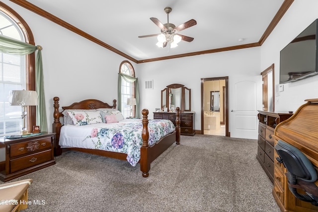 bedroom featuring carpet flooring, crown molding, ensuite bathroom, and a ceiling fan