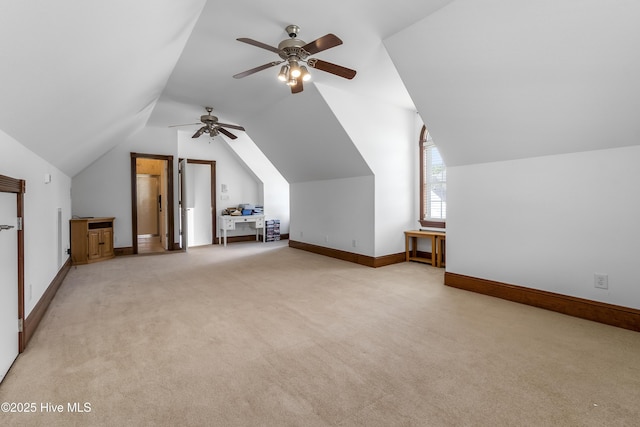 additional living space with a ceiling fan, light carpet, lofted ceiling, and baseboards