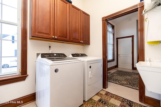 clothes washing area featuring cabinet space, washer and dryer, and healthy amount of natural light