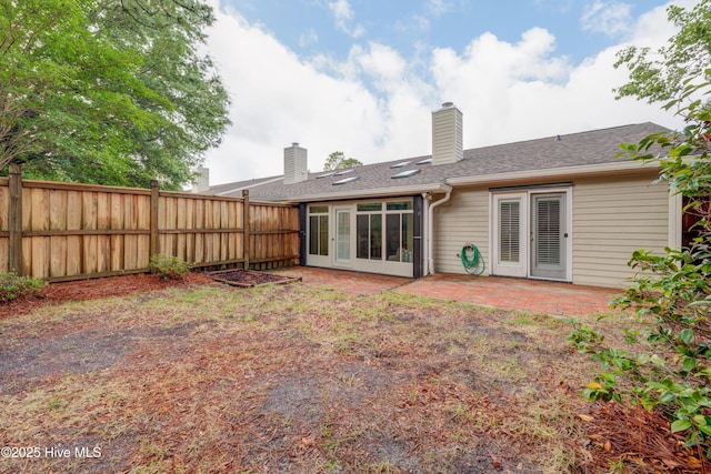 6025 Inland Greens Dr, Wilmington, NC 28405 - rear view of house with fence, a patio area, a chimney, and a shingled roof
