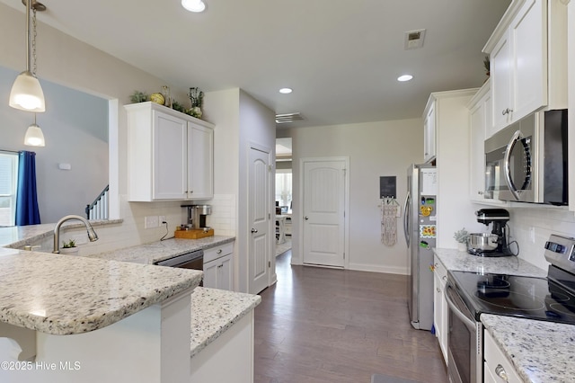 kitchen with appliances with stainless steel finishes, backsplash, light stone counters, white cabinets, and dark wood-style floors