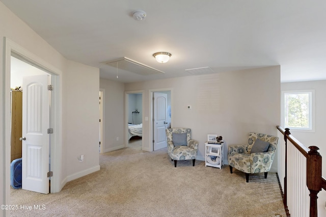sitting room featuring attic access, carpet floors, and baseboards