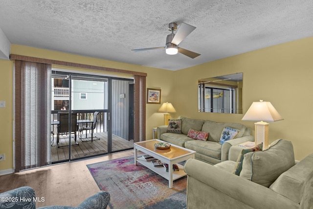 living area featuring wood finished floors, ceiling fan, and a textured ceiling