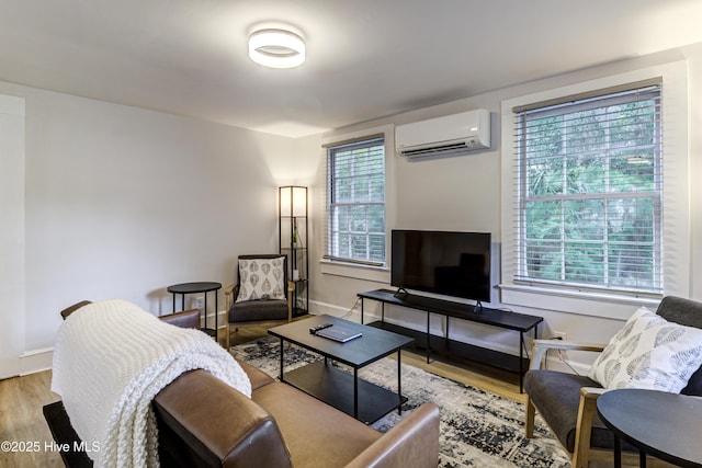 living area featuring a wall mounted AC, wood finished floors, and baseboards