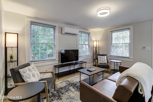 living room featuring a wall unit AC, plenty of natural light, wood finished floors, and baseboards